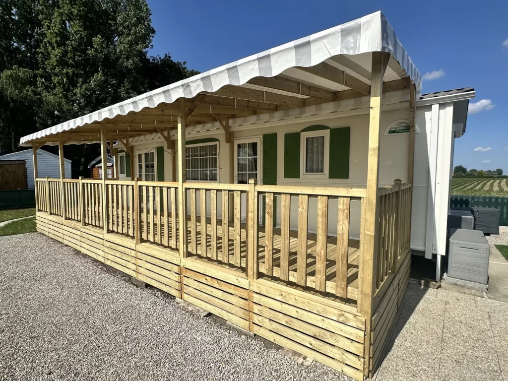 Bâche de toit rayée grise et blanche avec lambrequin sur une pergola de terrasse de mobil home